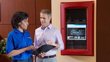 people using tab in from of a fire alarm