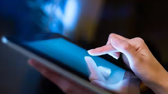 A person's finger tapping a tablet screen
